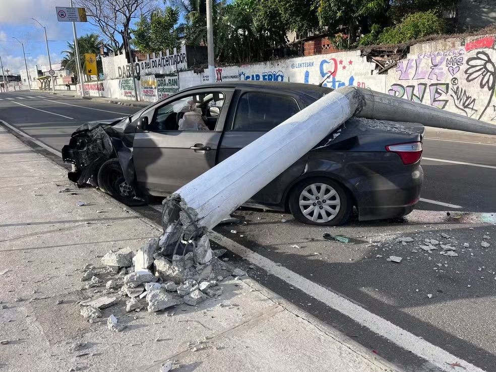 Poste cai sobre carro após colisão em Natal