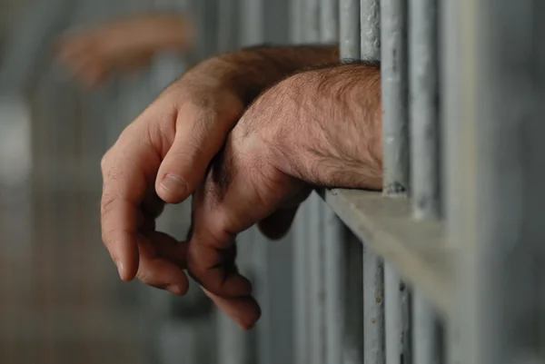 depositphotos_24076091-stock-photo-mans-hands-behind-bars-in.jpg
