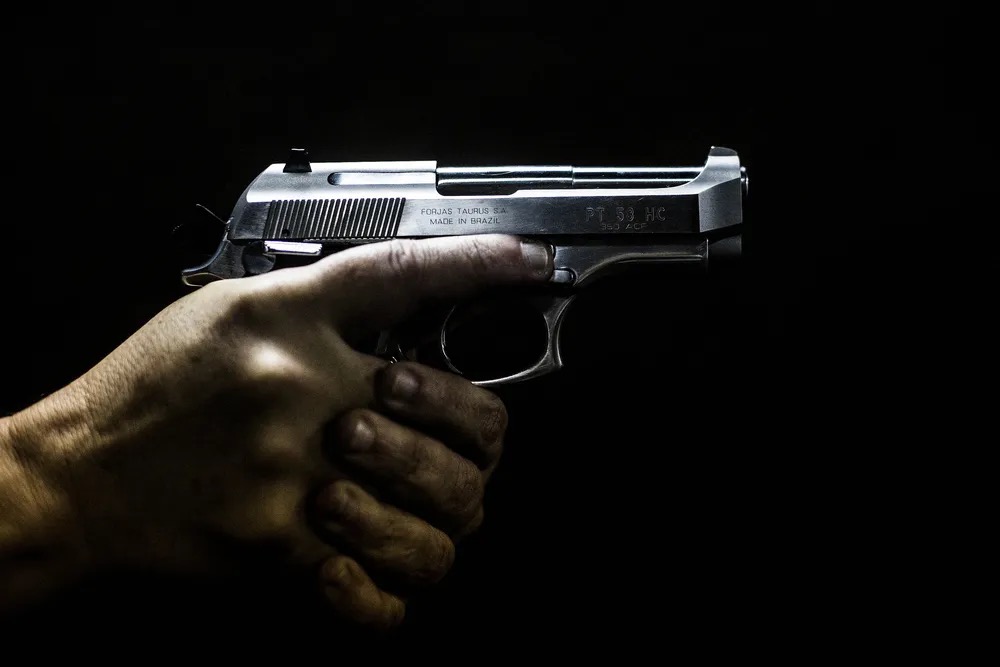 Homem segura uma arma no clube de tiro 'Calibre 12' em São Gonçalo, Rio de Janeiro, em imagem de setembro de 2018 — Foto: Daniel Ramalho/AFP/Arquivo