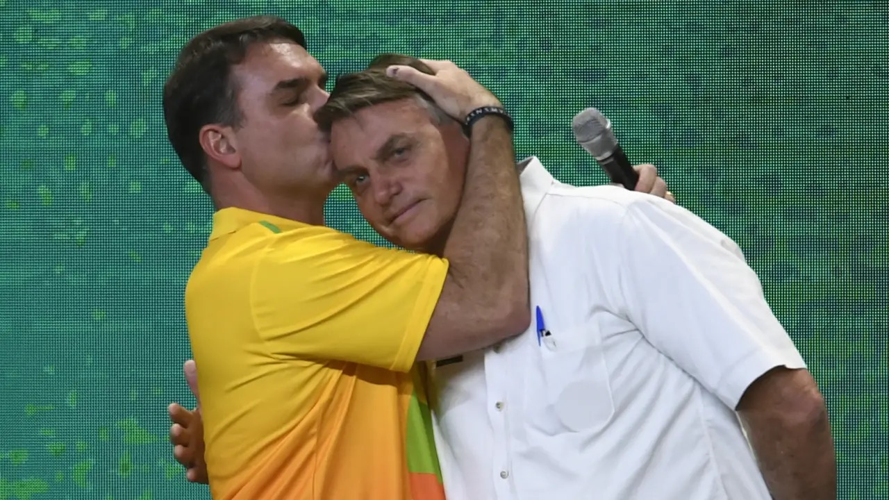 Flávio Bolsonaro beija o pai, Jair Bolsonaro, durante evento do PL em 2022 (Mateus Bonomi/Anadolu Agency via/Getty Images)
