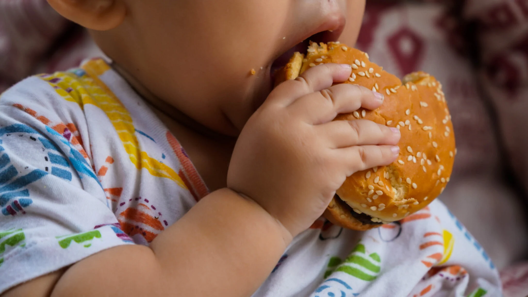 midsection-baby-holding-hamburger-scaled-1-2048x1152.webp