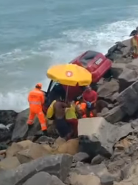 Carro cai sobre pedras e fica pendurado próximo ao mar em Natal; motorista é resgatada pelos bombeiros