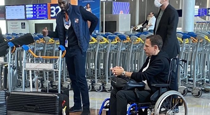 Imagem mostra Doria usando cadeira de rodas em aeroporto de Paris